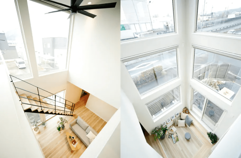 大きな窓と吹き抜け階段のある開放的なリビングの施工事例